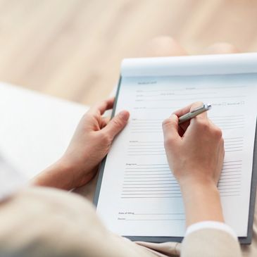 Psychiatric assessment with notepad and writing hands